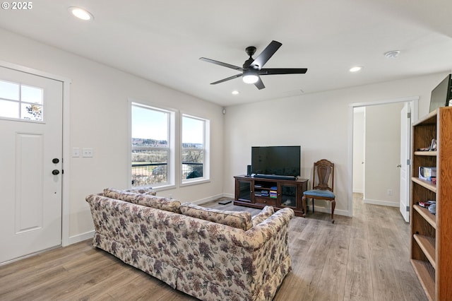 living room with recessed lighting, baseboards, and light wood-style flooring