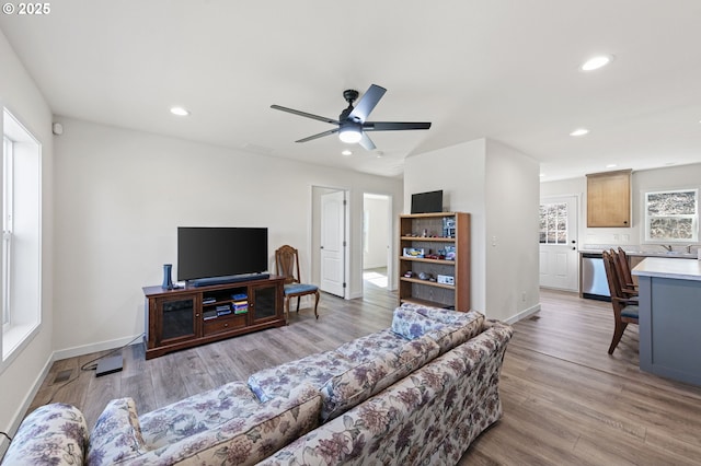 living area with a ceiling fan, recessed lighting, baseboards, and light wood finished floors