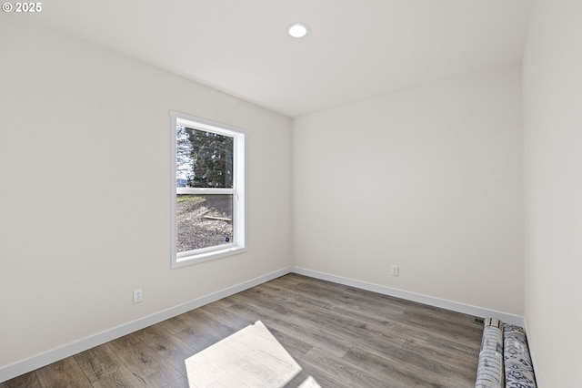 unfurnished room featuring recessed lighting, baseboards, and wood finished floors