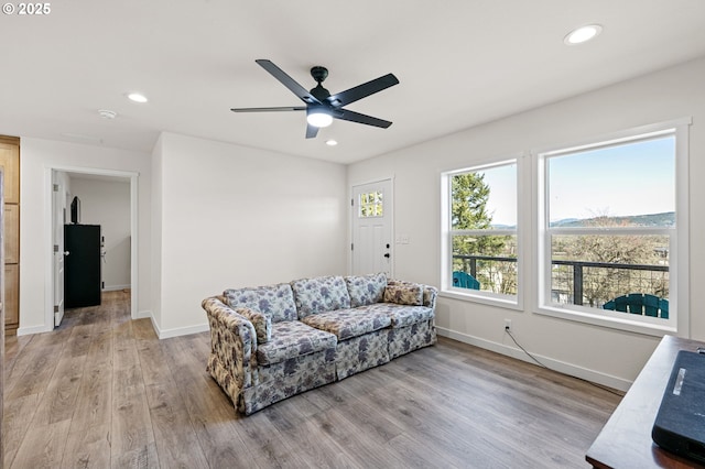 living area featuring recessed lighting, baseboards, and light wood finished floors