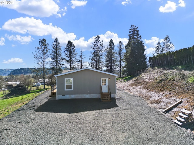 exterior space with crawl space, entry steps, and driveway