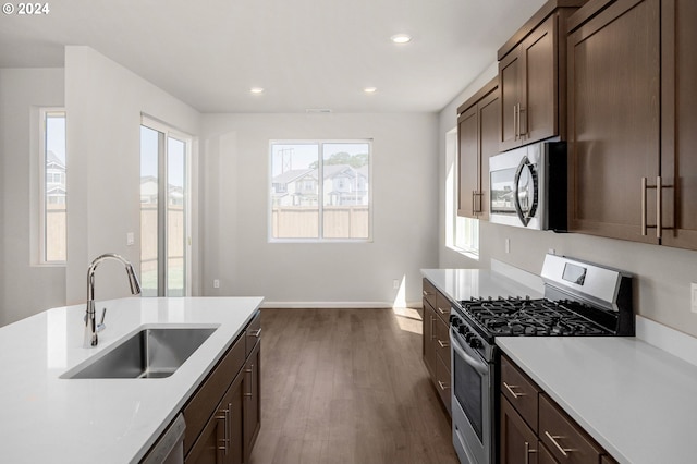 kitchen featuring sink, dark wood-type flooring, dark brown cabinets, and appliances with stainless steel finishes