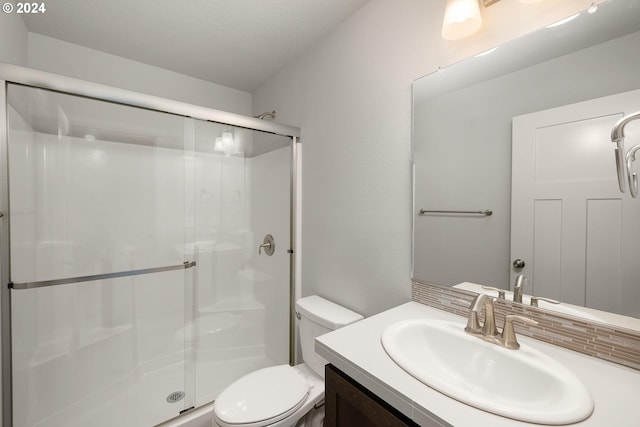 bathroom with vanity, toilet, an enclosed shower, and a textured ceiling