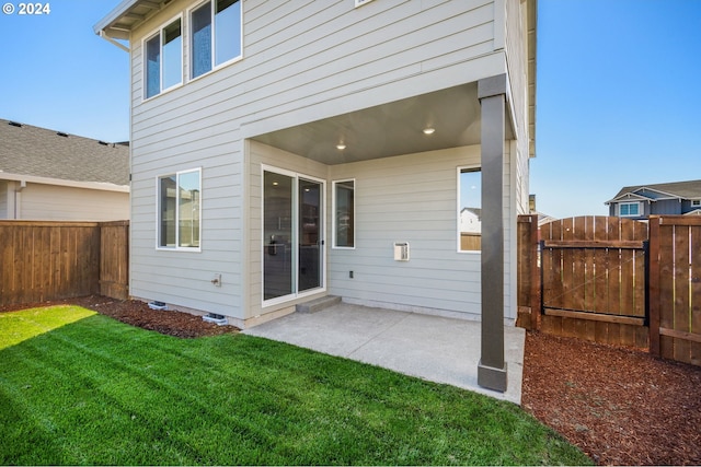 back of property with a yard and a patio area