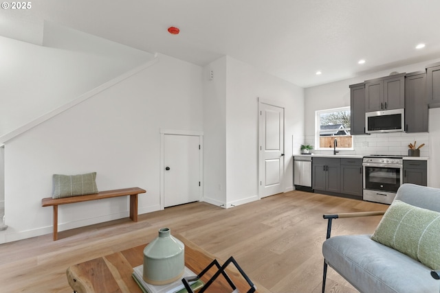 living room with baseboards, recessed lighting, and light wood-type flooring