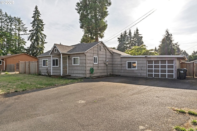 single story home featuring a garage and a front lawn