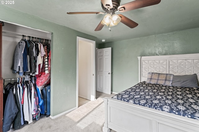 bedroom featuring light colored carpet, a closet, and ceiling fan