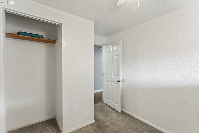 unfurnished bedroom featuring ceiling fan, a textured ceiling, and carpet