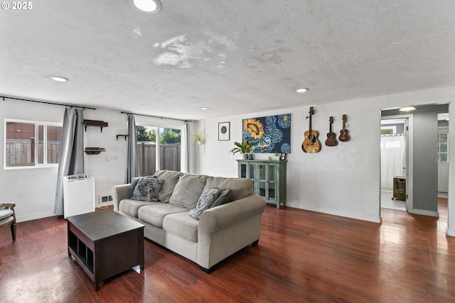 living room featuring a textured ceiling and dark hardwood / wood-style flooring