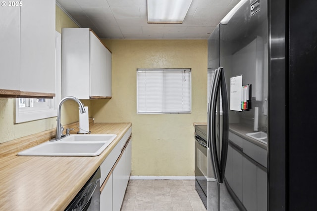 kitchen featuring sink, black appliances, and white cabinets