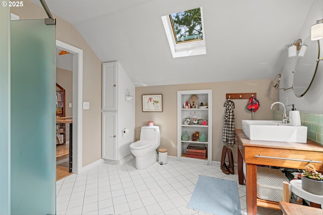 3416 SE 63rd Ave, Portland, OR 97206 - bathroom featuring lofted ceiling, a skylight, vanity, built in shelves, and toilet