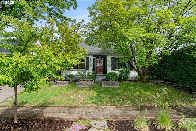3416 SE 63rd Ave, Portland, OR 97206 - view of property hidden behind natural elements featuring a vegetable garden, a front yard, and a shingled roof