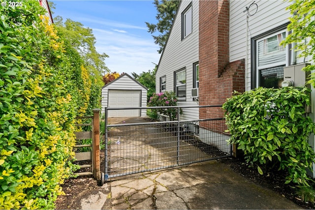 3416 SE 63rd Ave, Portland, OR 97206 - view of side of home featuring a detached garage, an outbuilding, concrete driveway, and a gate
