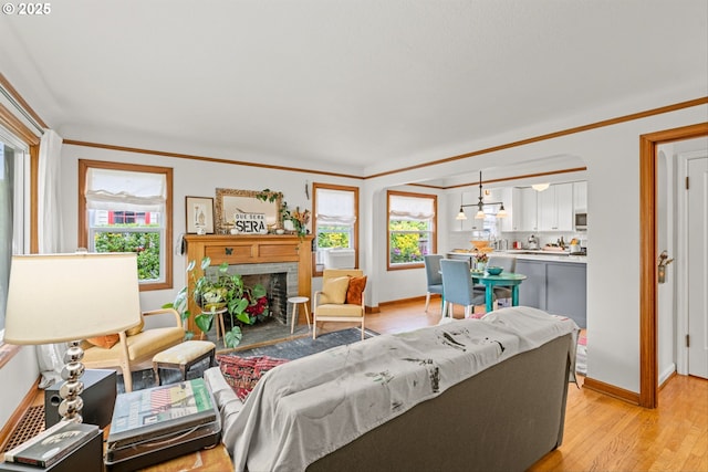 3416 SE 63rd Ave, Portland, OR 97206 - living room with plenty of natural light, a brick fireplace, light wood-style flooring, ornamental molding, and baseboards