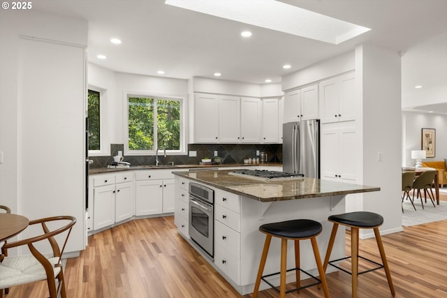 1911 NW Norfolk Ct, Portland, OR 97229 - kitchen featuring appliances with stainless steel finishes, light wood-style floors, white cabinetry, and recessed lighting