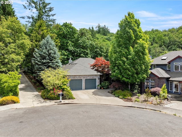 1911 NW Norfolk Ct, Portland, OR 97229 - obstructed view of property featuring concrete driveway, an attached garage, and brick siding