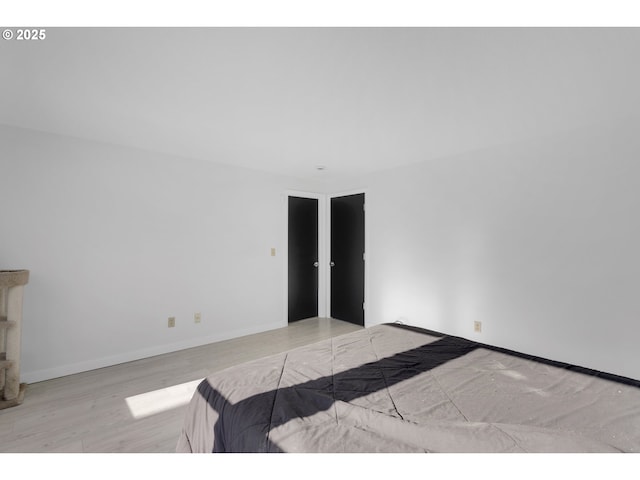 bedroom with wood finished floors and baseboards