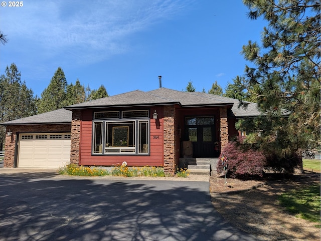 264 Mattie K Ln, Roseburg, OR 97471 - view of front facade featuring a garage, driveway, stone siding, and roof with shingles