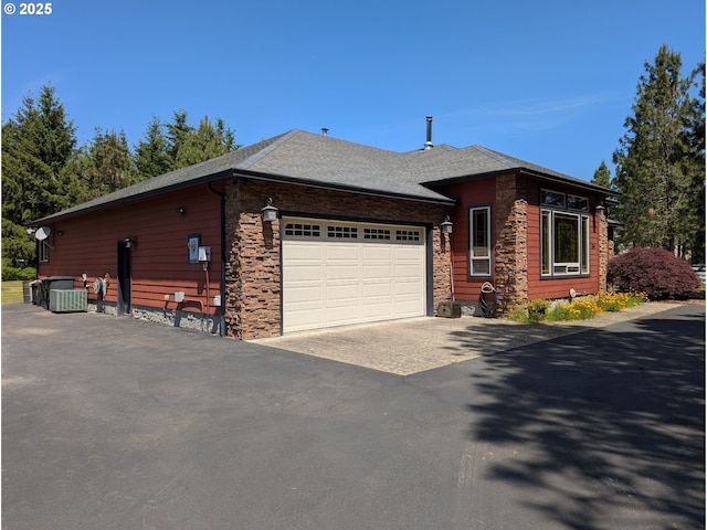 264 Mattie K Ln, Roseburg, OR 97471 - view of front facade featuring an attached garage, asphalt driveway, stone siding, and roof with shingles