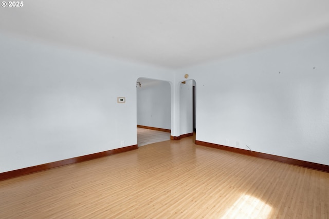 1710 Norkenzie Rd, Eugene, OR 97401 - spare room with arched walkways, light wood finished floors, and baseboards