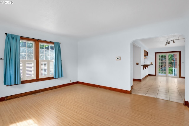 1710 Norkenzie Rd, Eugene, OR 97401 - empty room with rail lighting, healthy amount of natural light, arched walkways, and baseboards