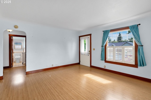 1710 Norkenzie Rd, Eugene, OR 97401 - spare room with plenty of natural light, arched walkways, wood finished floors, and baseboards