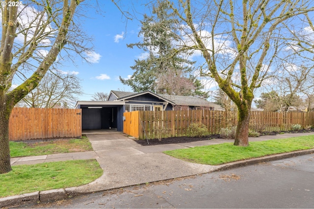 view of front of home featuring a fenced front yard, a carport, and driveway