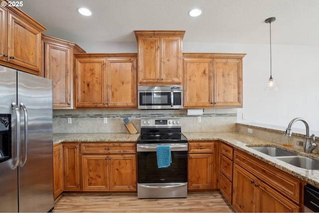 229 N 33rd Ct, Ridgefield, WA 98642 - kitchen with stainless steel appliances, a sink, light stone countertops, light wood-type flooring, and recessed lighting