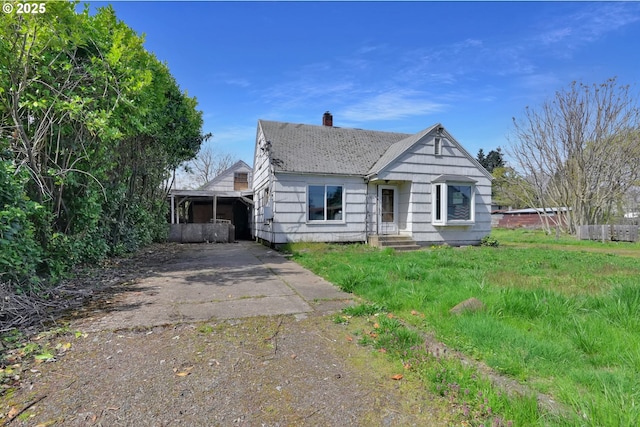 view of front of home with driveway and a chimney