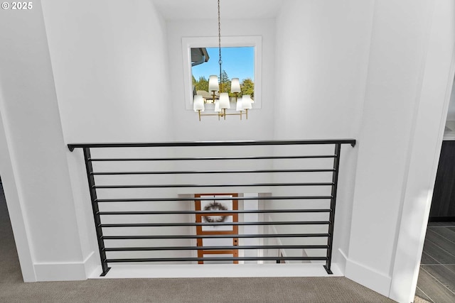 details featuring carpet flooring, a notable chandelier, and baseboards