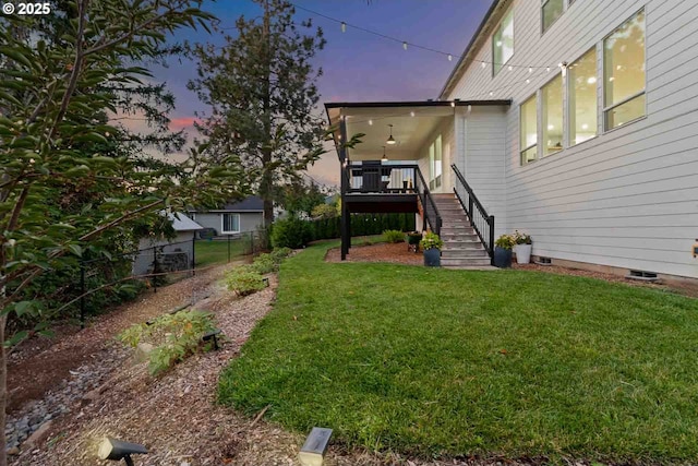 view of yard featuring a deck, stairway, and fence