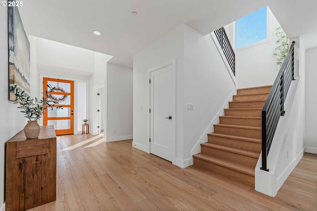 foyer entrance with recessed lighting, stairs, light wood-type flooring, and baseboards