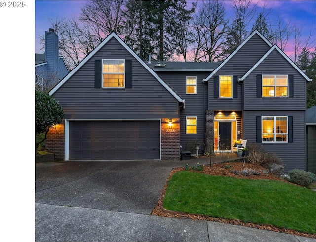 traditional-style house featuring driveway, a garage, and brick siding