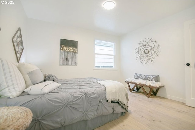 bedroom with light wood-style flooring and baseboards