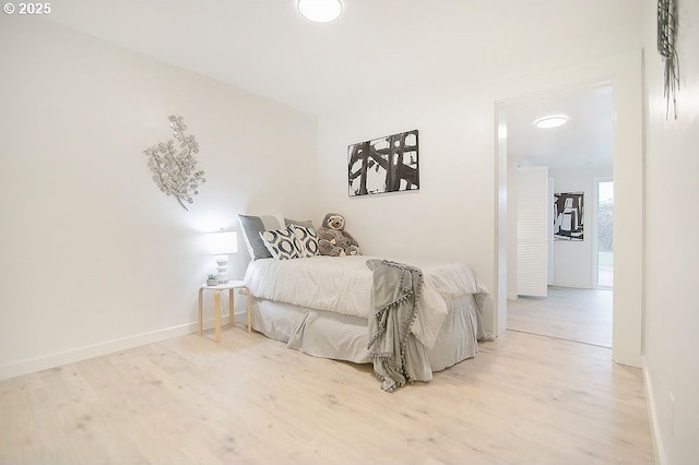 bedroom with light wood-style flooring and baseboards