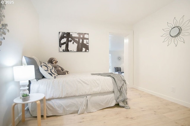 bedroom with light wood-type flooring and baseboards