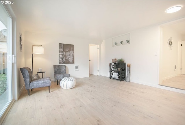 sitting room featuring light wood-style floors and visible vents