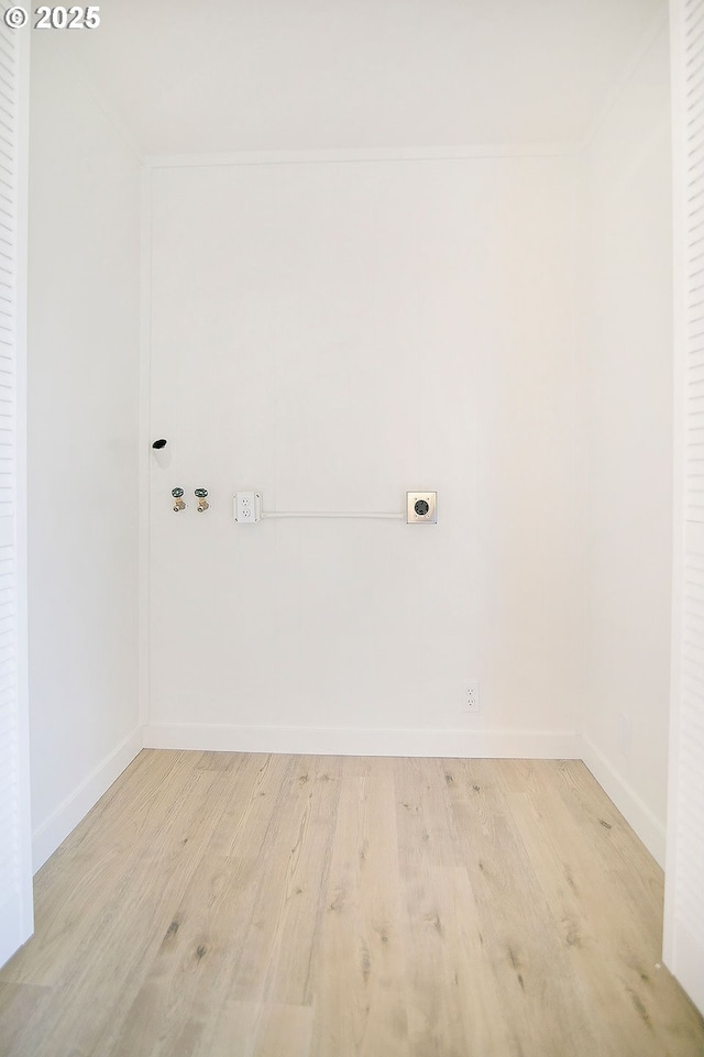 clothes washing area with hookup for an electric dryer, laundry area, washer hookup, baseboards, and light wood-style floors