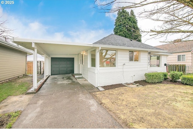 view of front of house with a garage, brick siding, fence, driveway, and roof with shingles