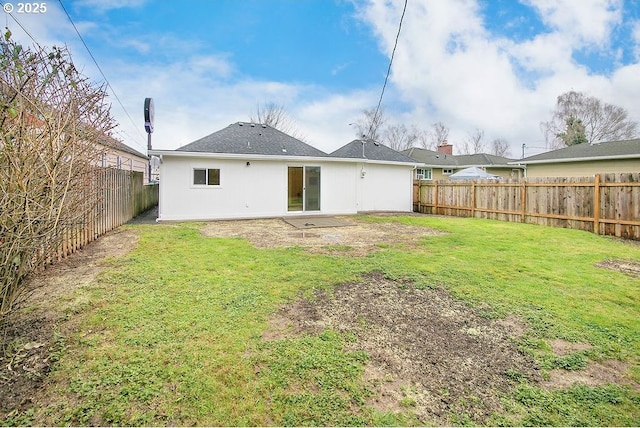 back of house featuring a lawn and a fenced backyard