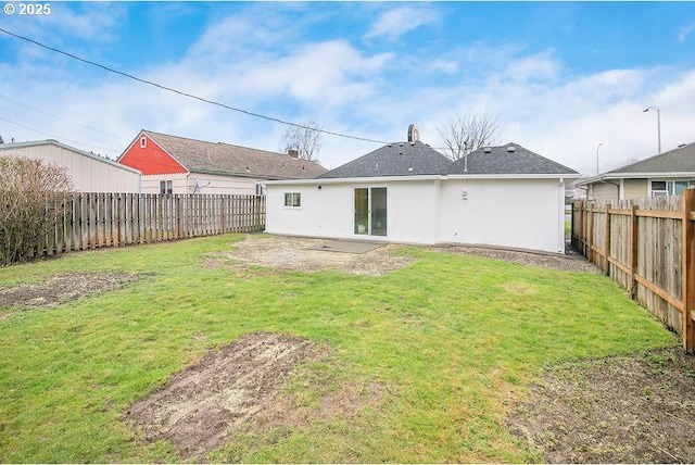 rear view of house featuring stucco siding, a fenced backyard, a patio, and a yard