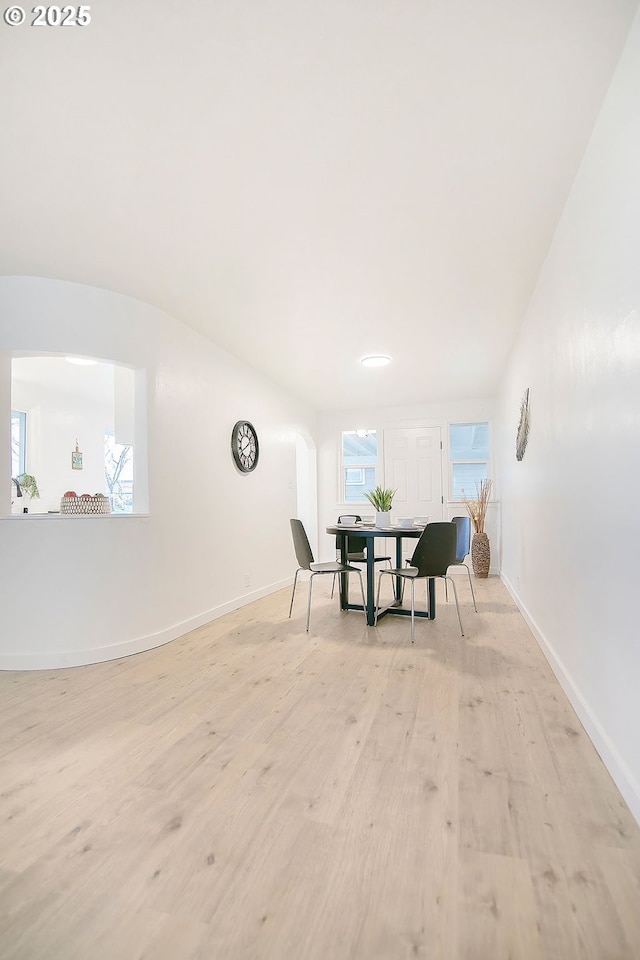 dining space featuring light wood-style flooring and baseboards