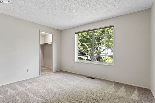 6095 SW Erickson Ave, Beaverton, OR 97008 - unfurnished bedroom with carpet, a walk in closet, a textured ceiling, a closet, and baseboards