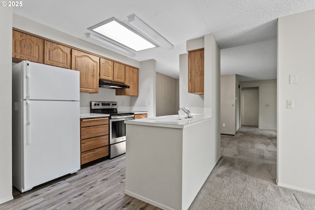 6095 SW Erickson Ave, Beaverton, OR 97008 - kitchen featuring freestanding refrigerator, stainless steel range with electric cooktop, under cabinet range hood, a sink, and light countertops