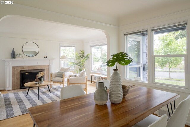 2416 SE 60th Ave, Portland, OR 97206 - dining area with arched walkways, a tile fireplace, and light wood finished floors