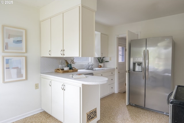 2416 SE 60th Ave, Portland, OR 97206 - kitchen with stainless steel refrigerator with ice dispenser, stove, a peninsula, light countertops, and white cabinets