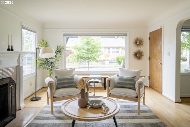 2416 SE 60th Ave, Portland, OR 97206 - sitting room featuring arched walkways, healthy amount of natural light, a fireplace, and light wood-type flooring