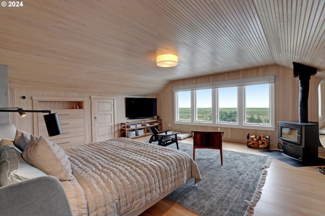 486 N Ocean Ave, Gearhart, OR 97138 - bedroom with wooden walls, a wood stove, lofted ceiling, wood ceiling, and wood finished floors