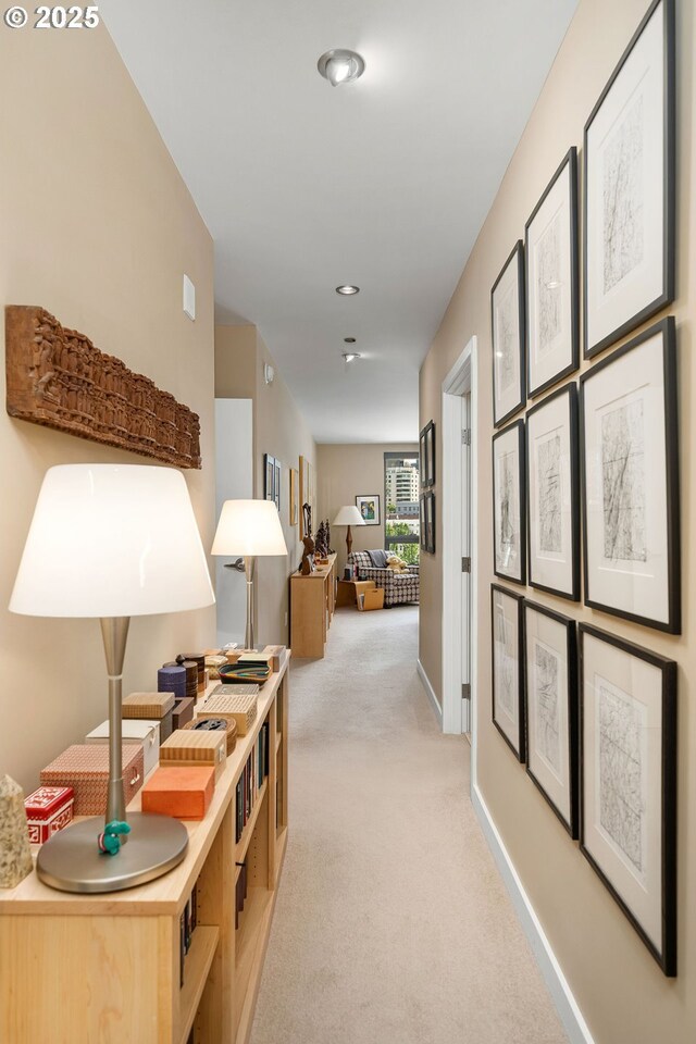 corridor featuring light carpet, baseboards, and recessed lighting