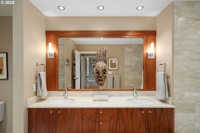 bathroom with double vanity and toilet